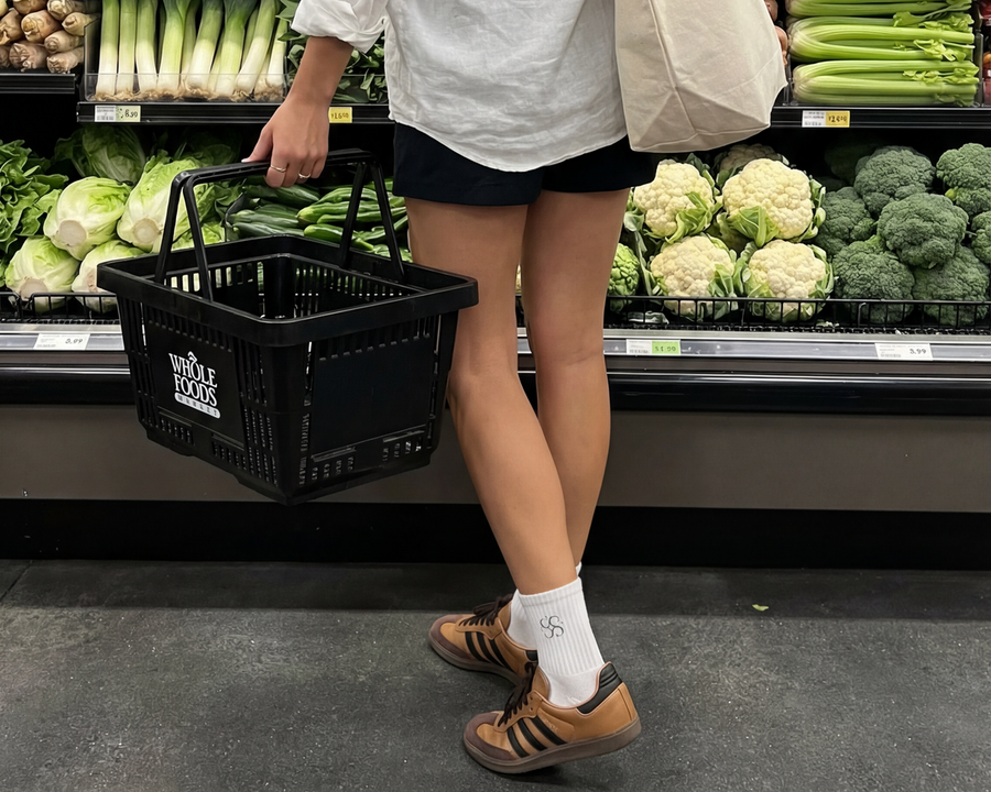 Frau beim Einkaufen im Supermarkt mit Studio Élancé Tasche und weißen Socken – Lifestyle-Foto